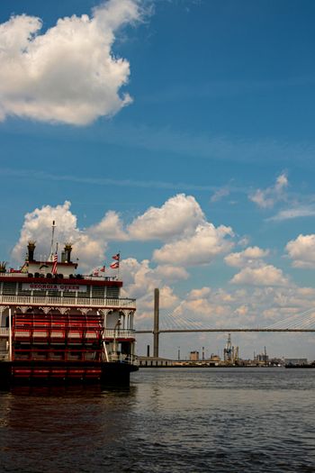 red and white ship on sea under blue sky and white clouds during daytime