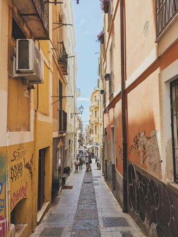 a narrow city street with graffiti on the buildings