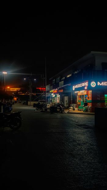 a dark parking lot with a motorcycle parked in front of it