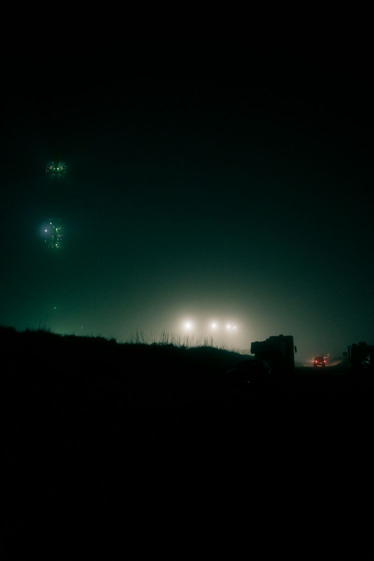 a couple of trucks driving down a road at night