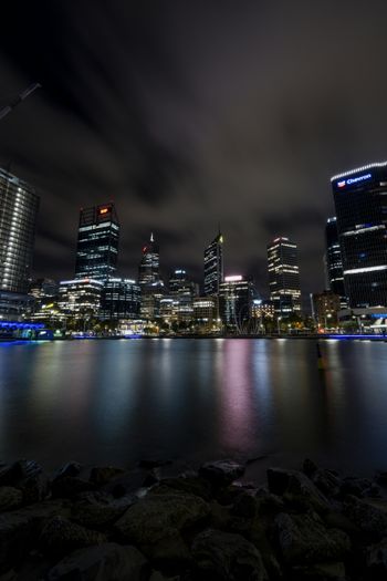 a city at night with lights reflecting off the water