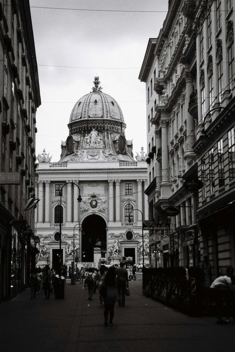 a black and white photo of people walking down a street