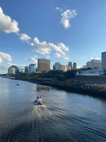 a group of people on a boat in a body of water with buildings in the background