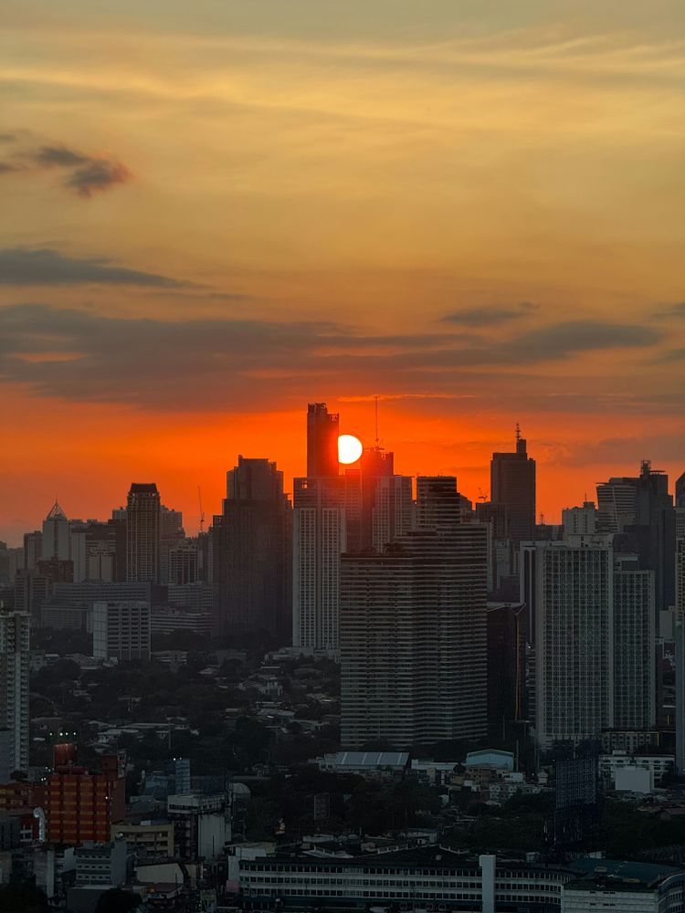 the sun is setting over a large city