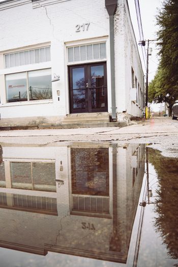 a reflection of a building in a puddle of water