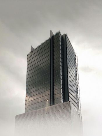 a very tall building sitting in the middle of a foggy sky