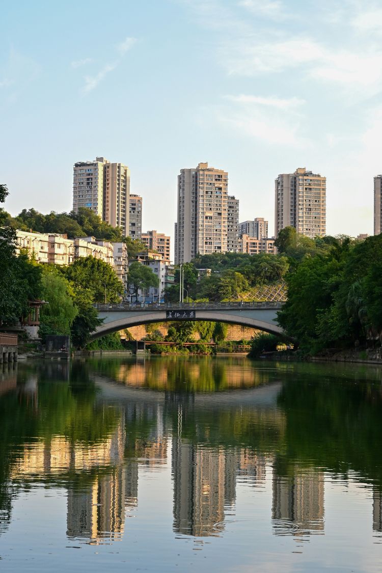 A bridge over a body of water with buildings in the background