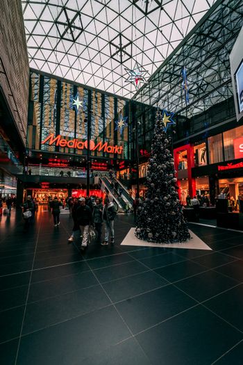 a christmas tree in a shopping mall with people walking around