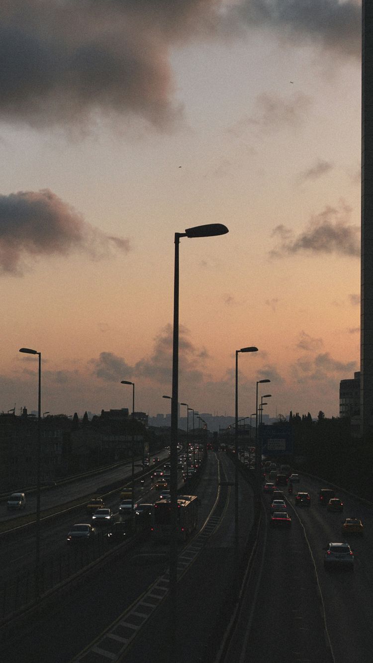 A city street filled with lots of traffic under a cloudy sky