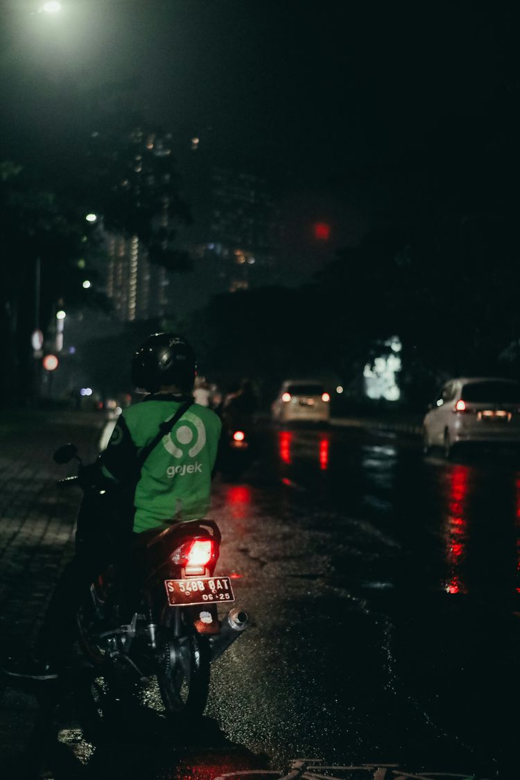 a man riding a motorcycle down a street at night