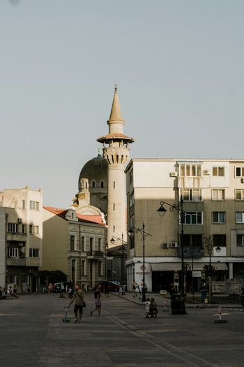 people walking on street near white concrete building during daytime