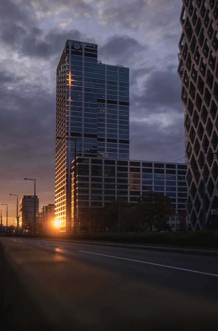 the sun is setting in a city with tall buildings