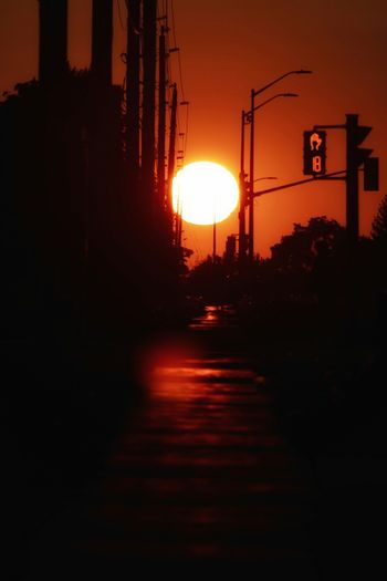 the sun is setting over a city street