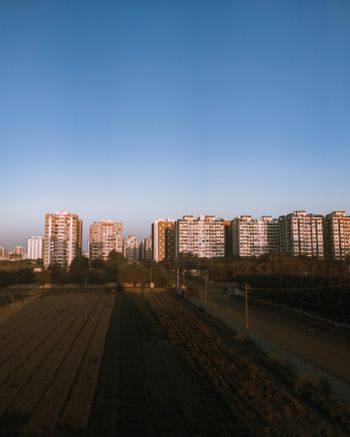 a large field in front of some tall buildings