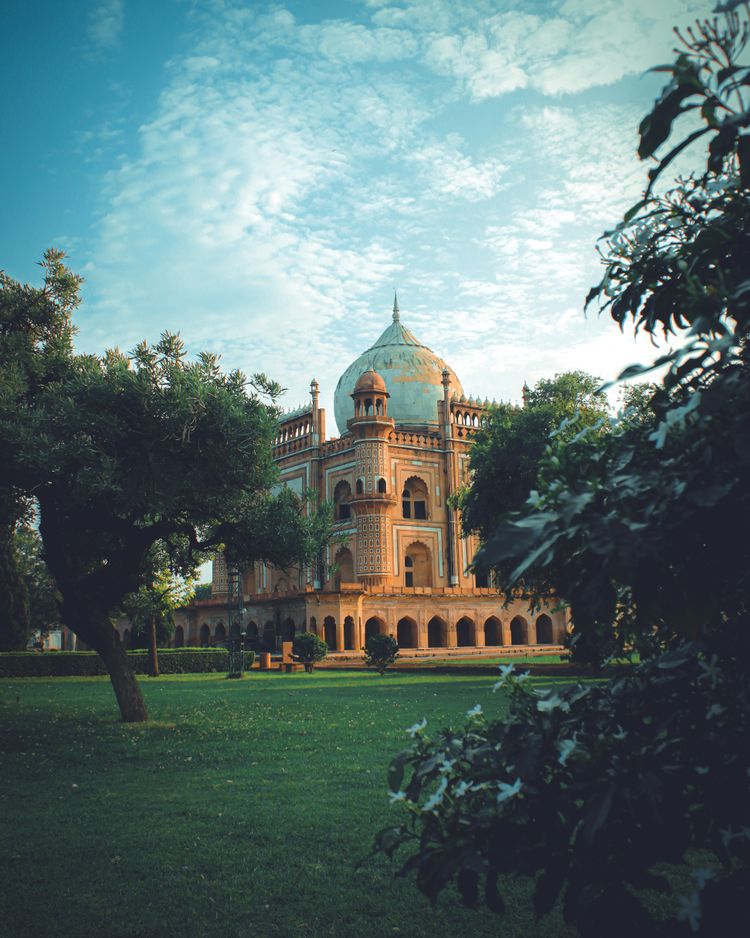 a large building with a dome and trees in front of it