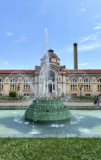 A large building with a fountain in front of it