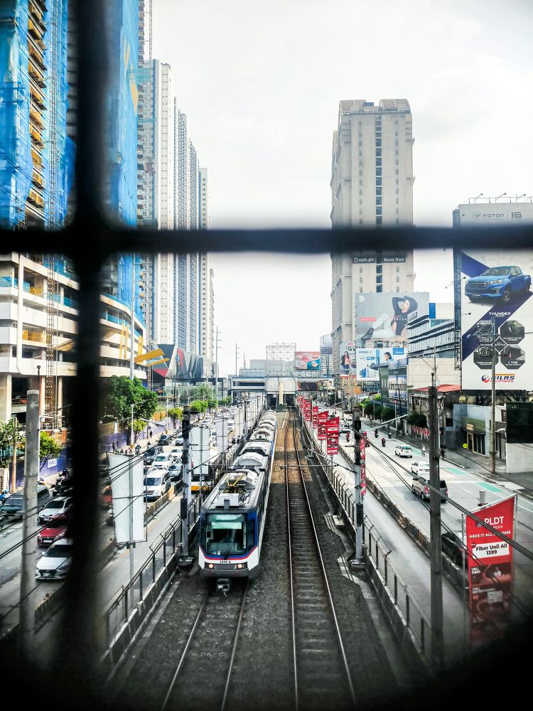 a train traveling down train tracks next to tall buildings