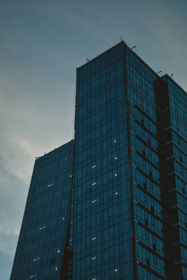 blue and black glass walled high rise building