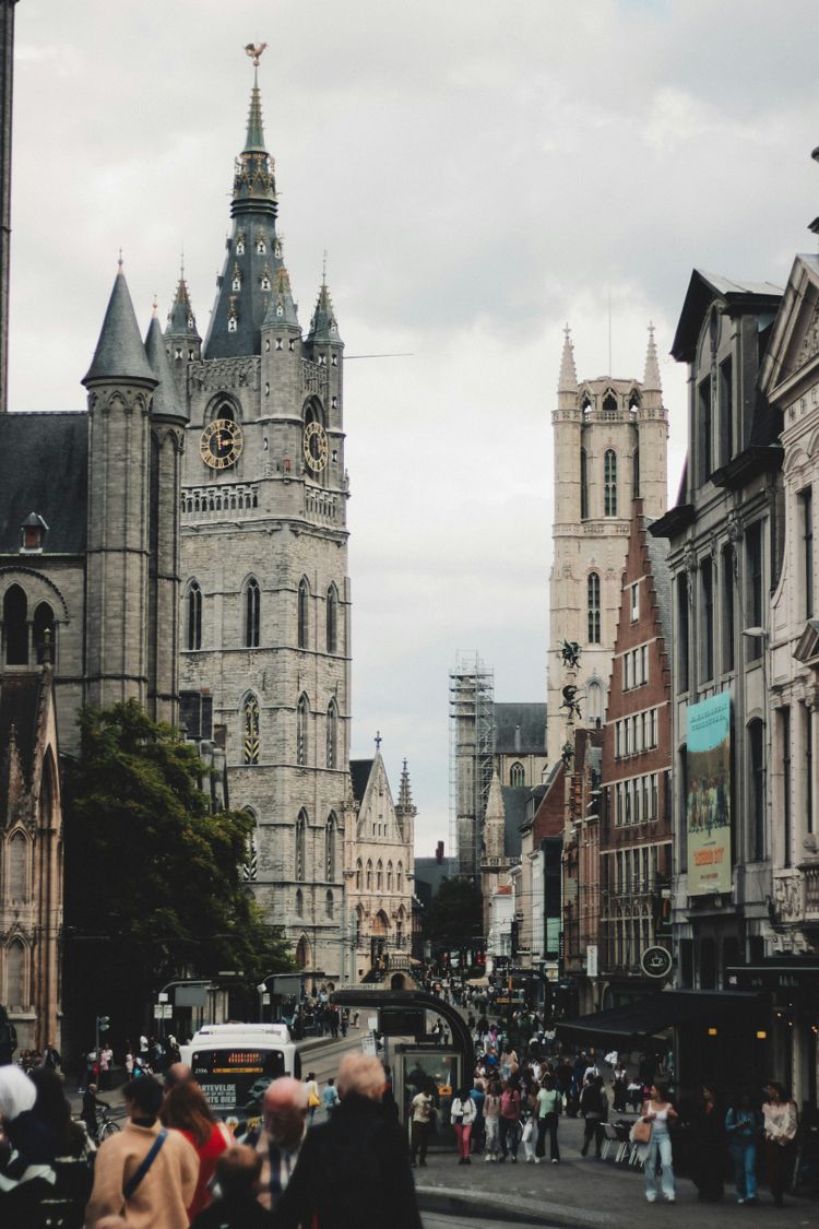 a crowd of people walking down a street next to tall buildings