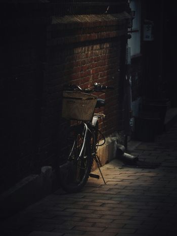 A bike parked next to a brick wall