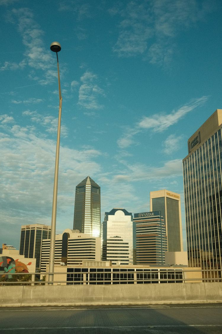 a city skyline with tall buildings and a street light