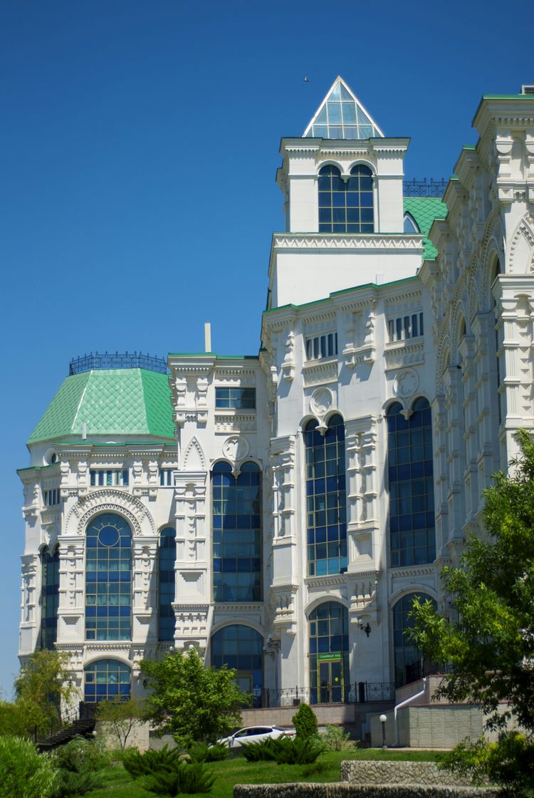 A large white building with a green roof