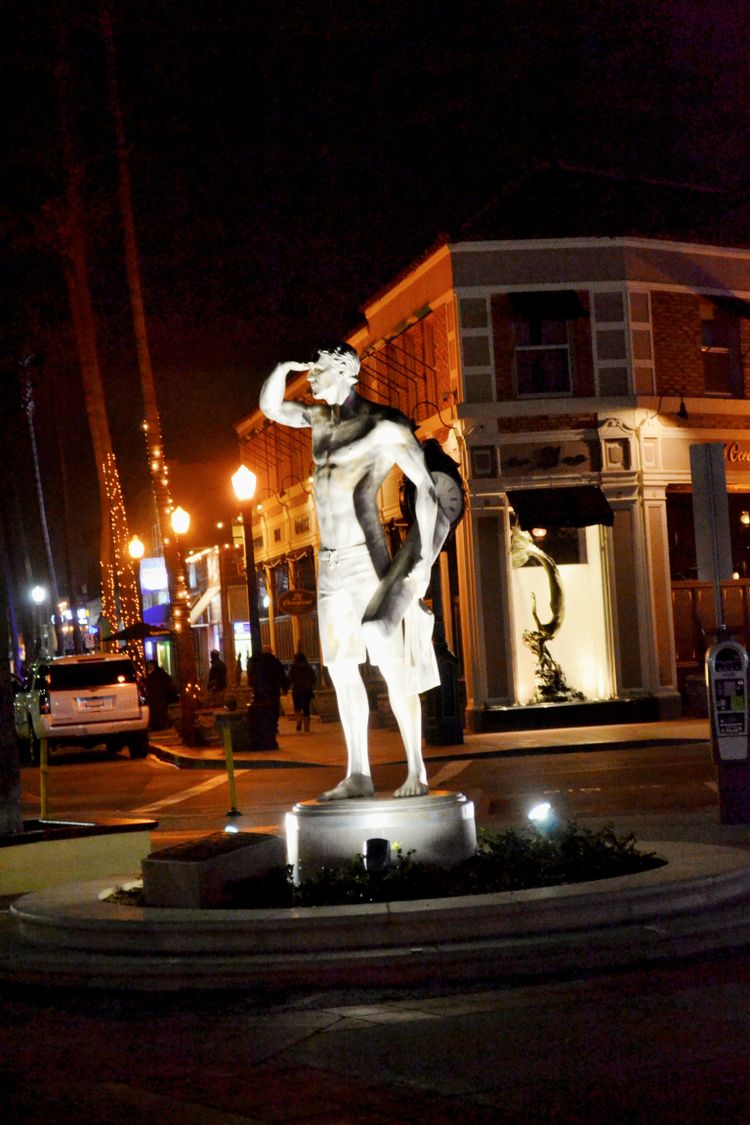 a statue of a man standing in the middle of a street