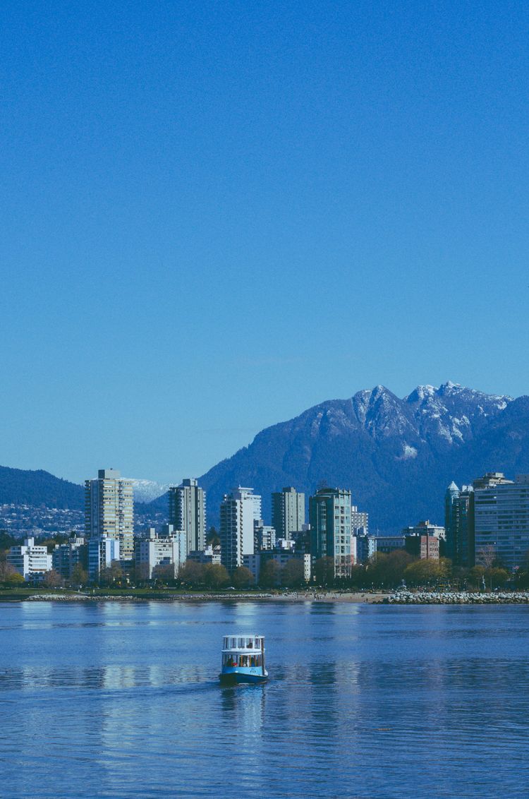 a boat floating on a lake in front of a city