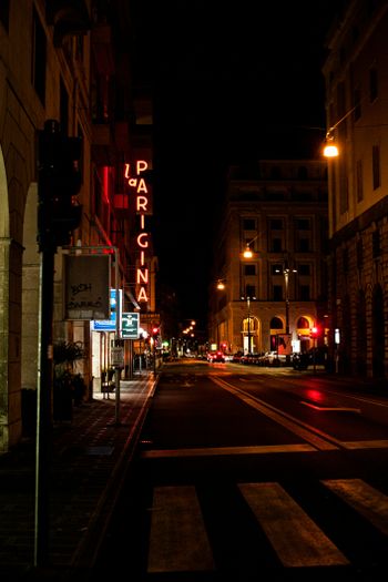 cars on road in between buildings during night time