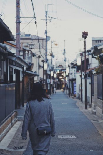 woman wearing gray dress walking on street