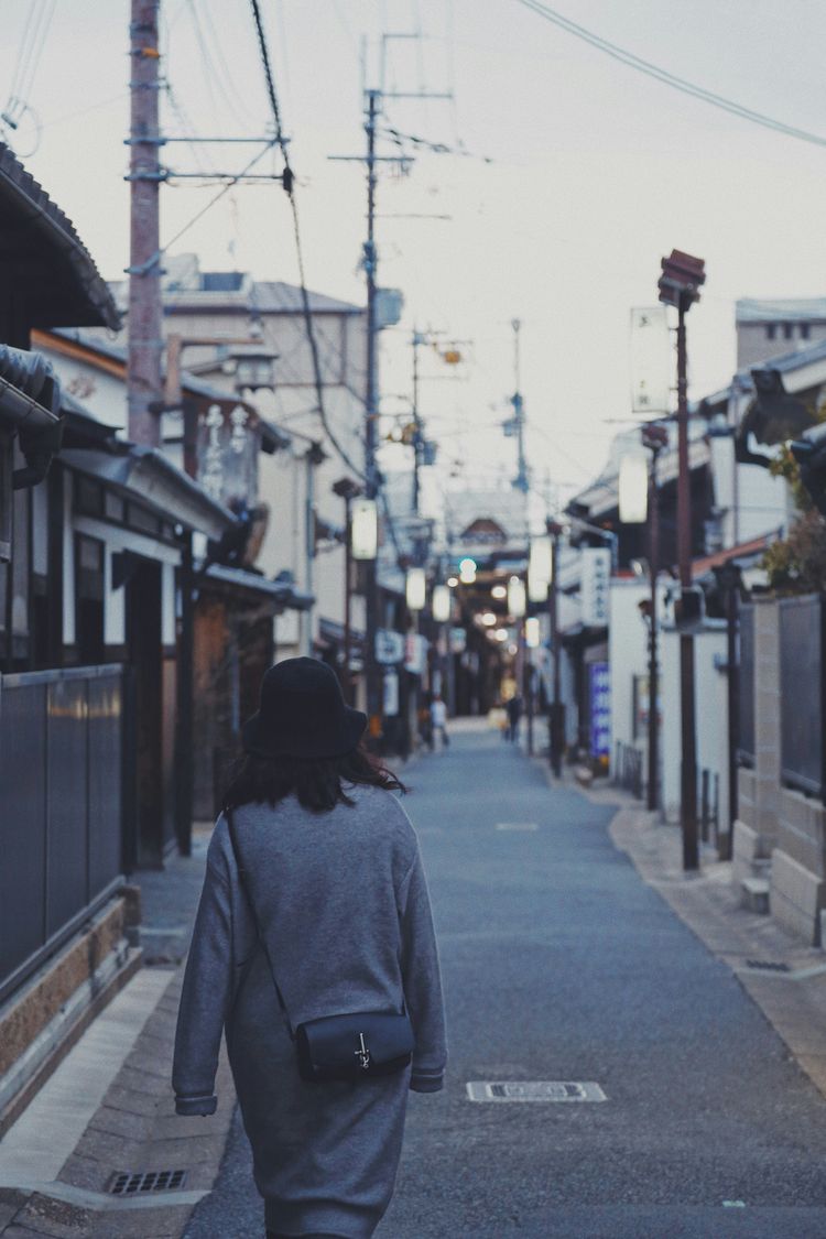 woman wearing gray dress walking on street