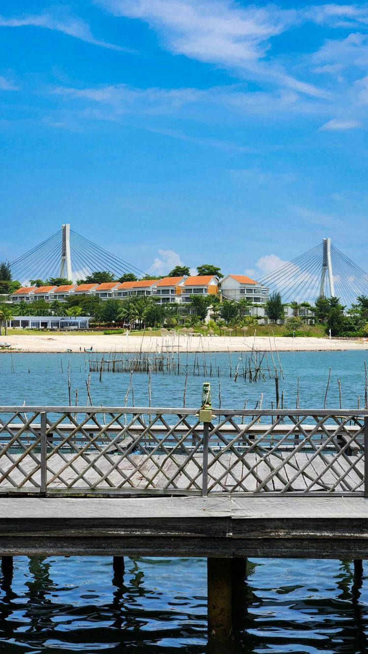 A pier with a view of a bridge in the background