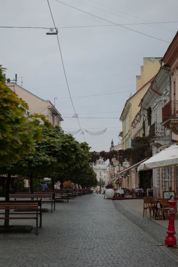 a cobblestone street lined with benches and tables