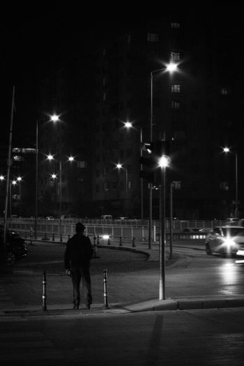 a man walking down a street at night