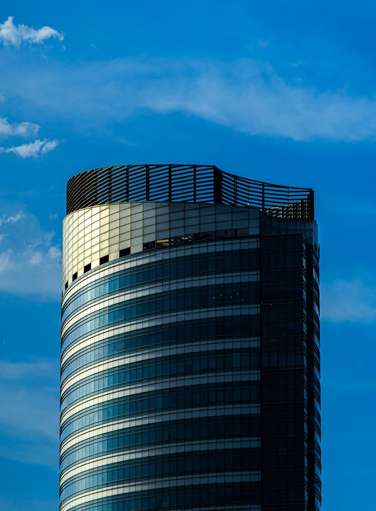 a very tall building with a plane flying in the sky