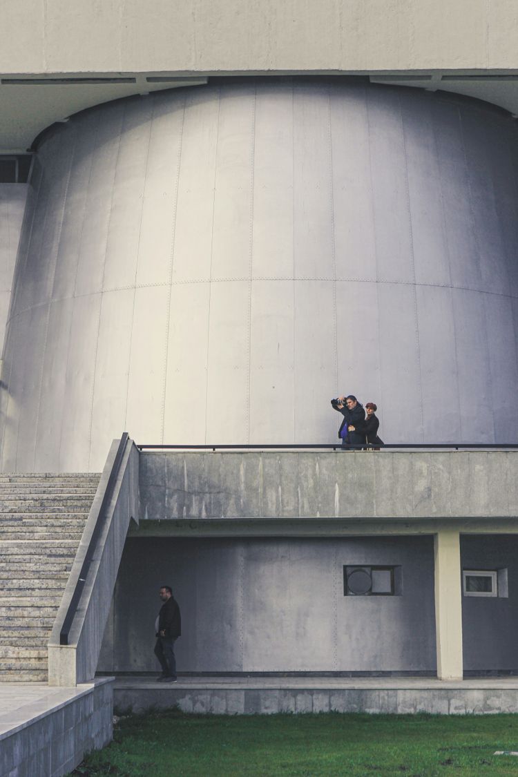 man in black jacket sitting on gray concrete stairs