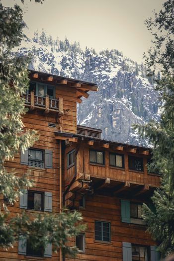 a large wooden building with a mountain in the background