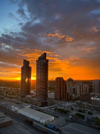 a sunset over a city with tall buildings