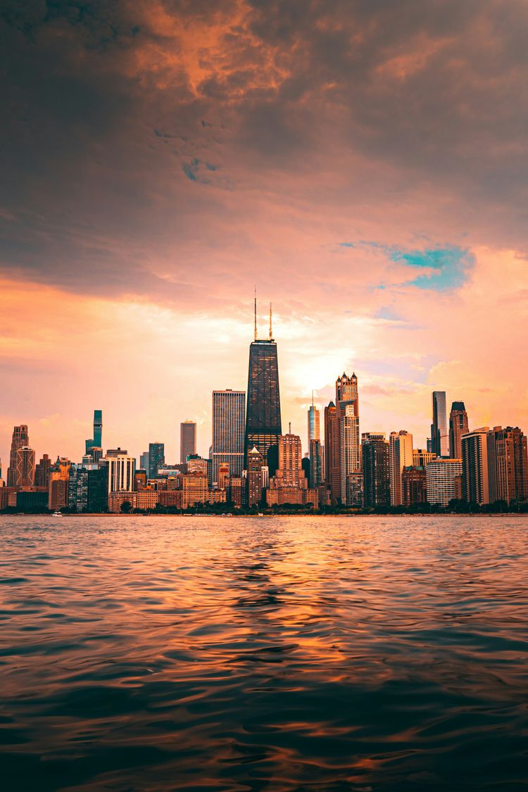 a view of a city from the water at sunset