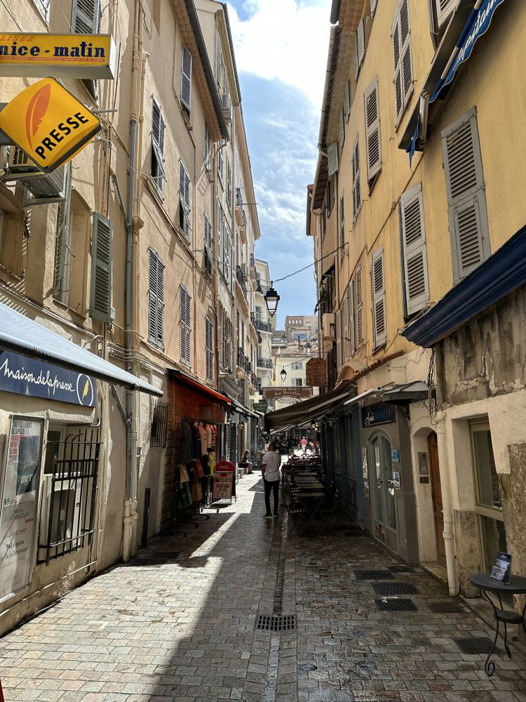 a narrow street with people walking down it