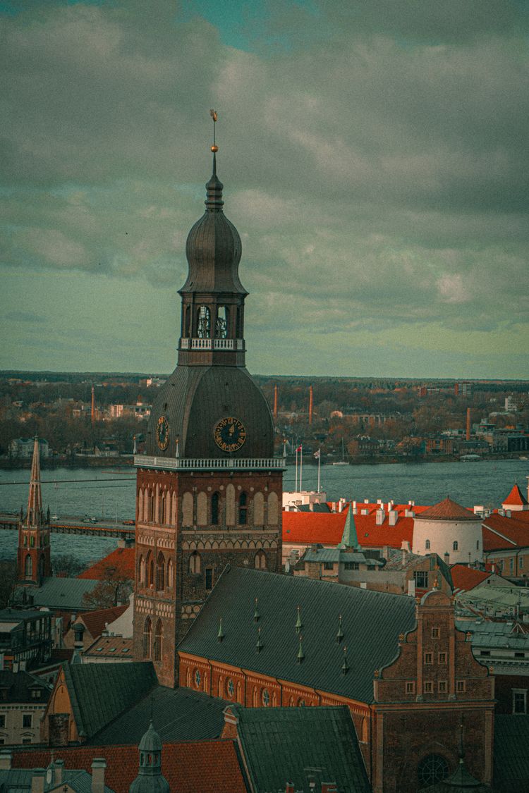 a clock tower on top of a building near a body of water