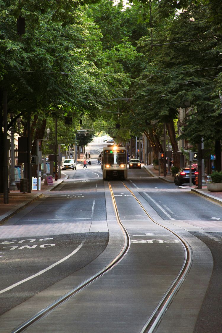 A trolley is coming down the tracks in the city